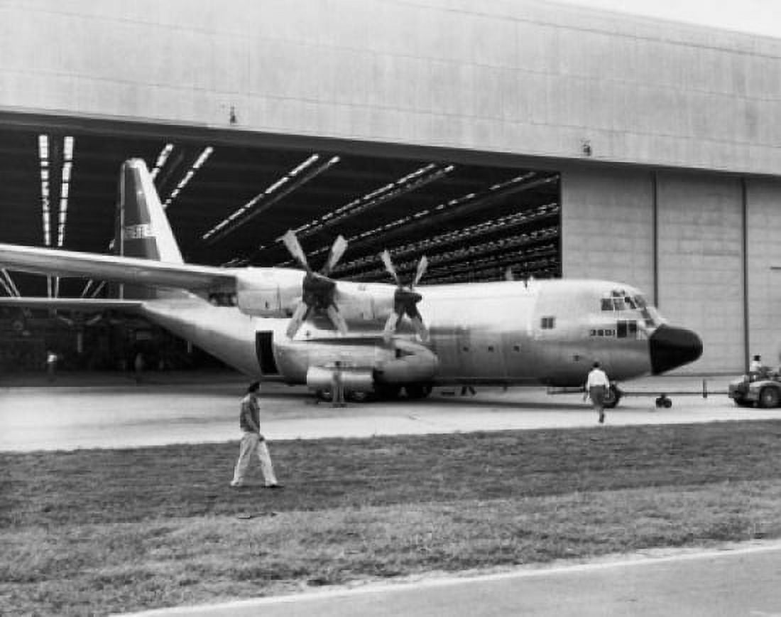 Land vehicle hauling an airplane out of a hanger C-130B Hercules Canvas Art - (24 x 36)