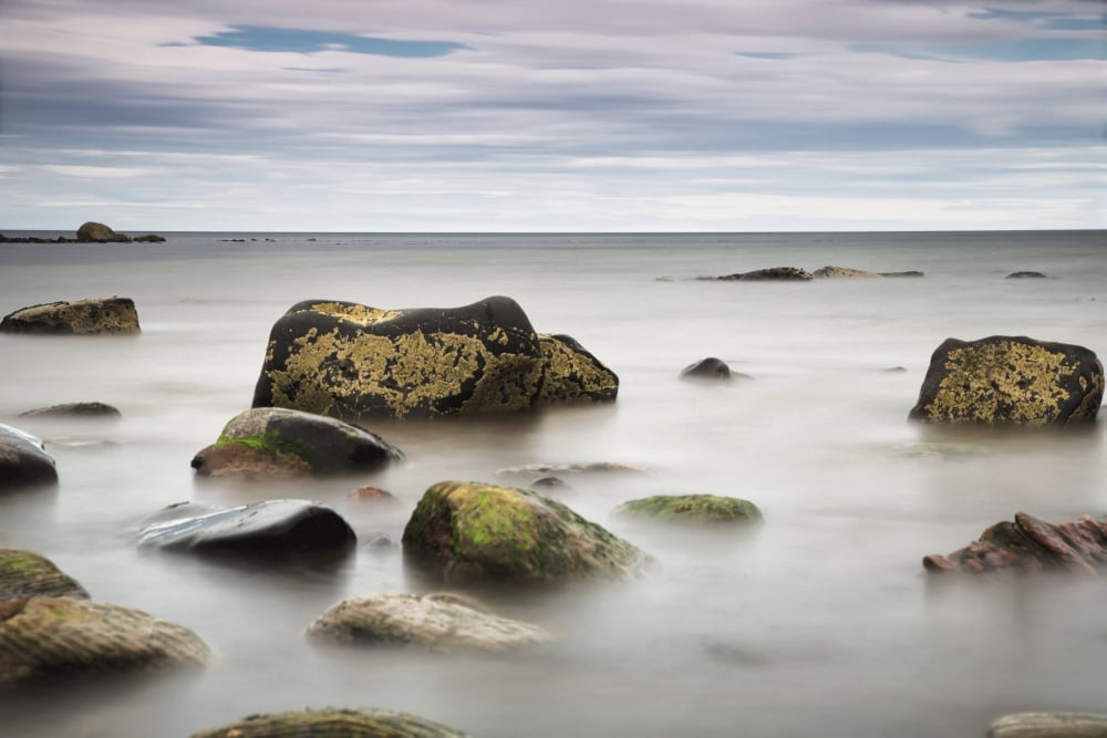 Large rocks sitting in the water Canvas Art - John Short Design Pics (19 x 12)