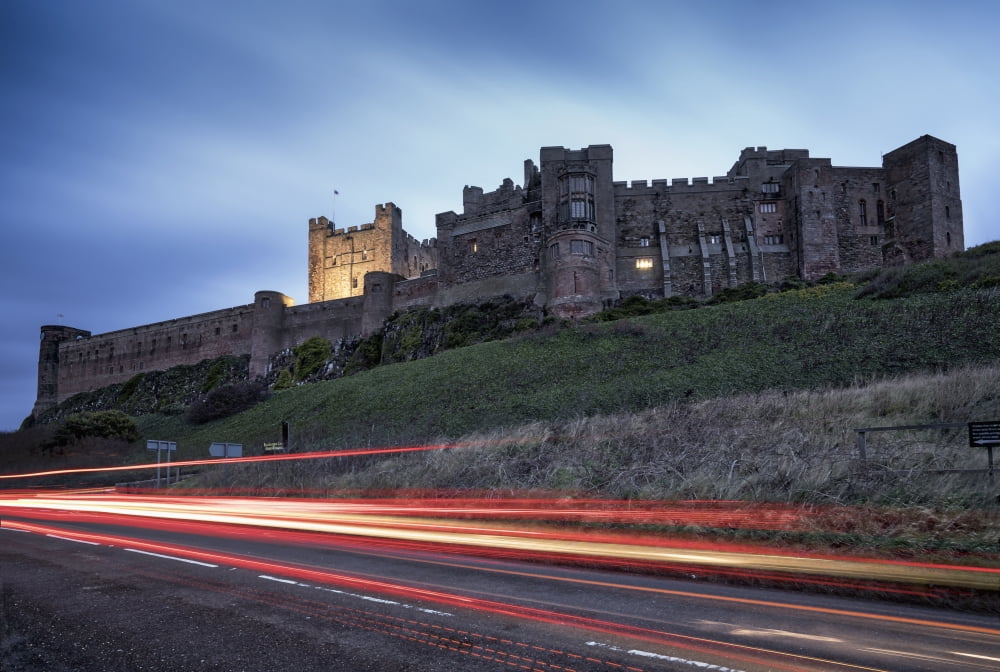 Light trails on the road and Bamburgh Castle Bamburgh Northumberland England Canvas Art - John Short Design Pics (38 x 24)