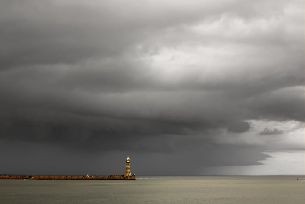 Lighthouse at the end of a pier with dark storm clouds overhead Sunderland Tyne and Wear England Canvas Art - John Short Design Pics (19 x 12)