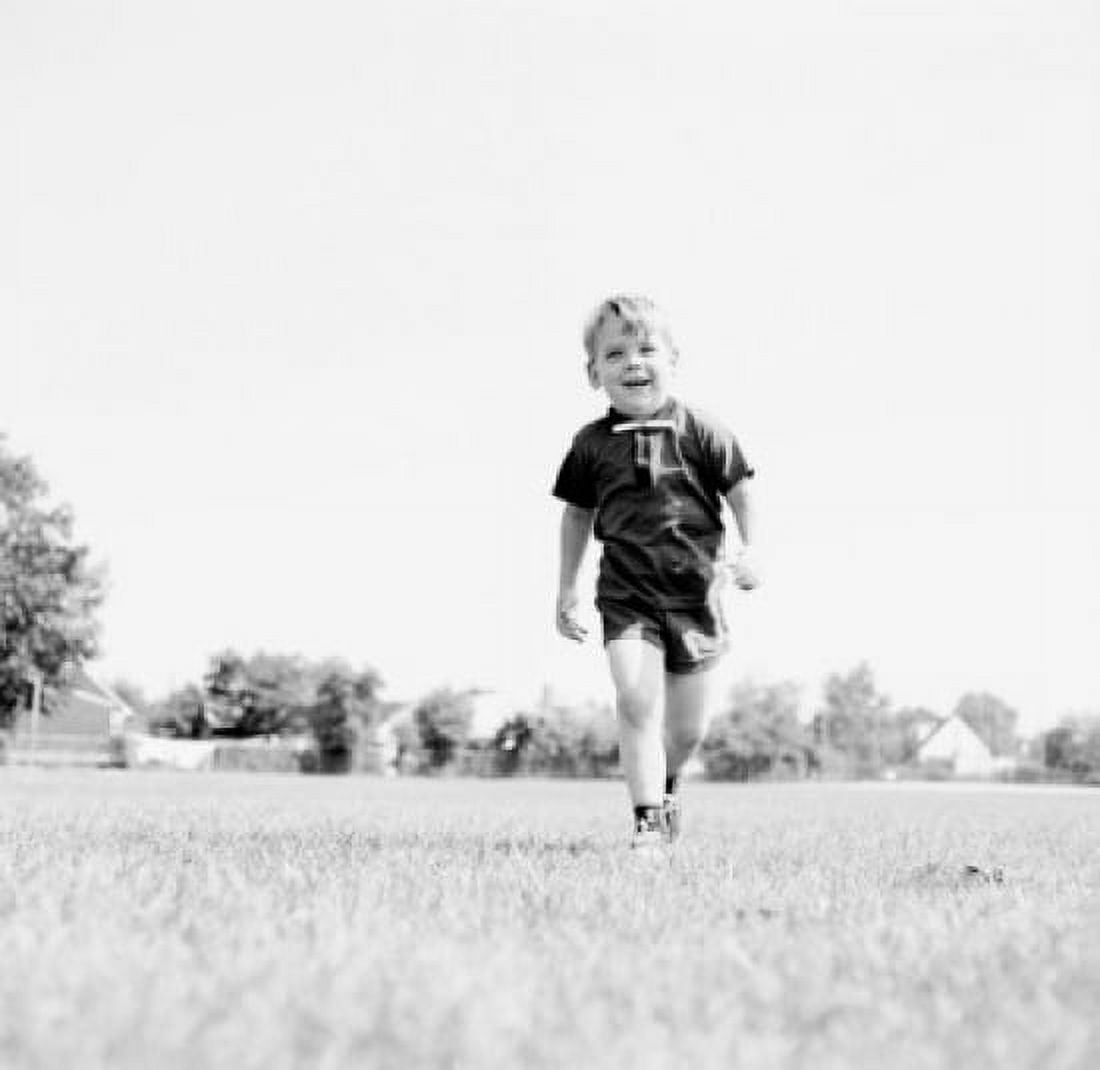 Little boy walking on field Canvas Art - (24 x 36)