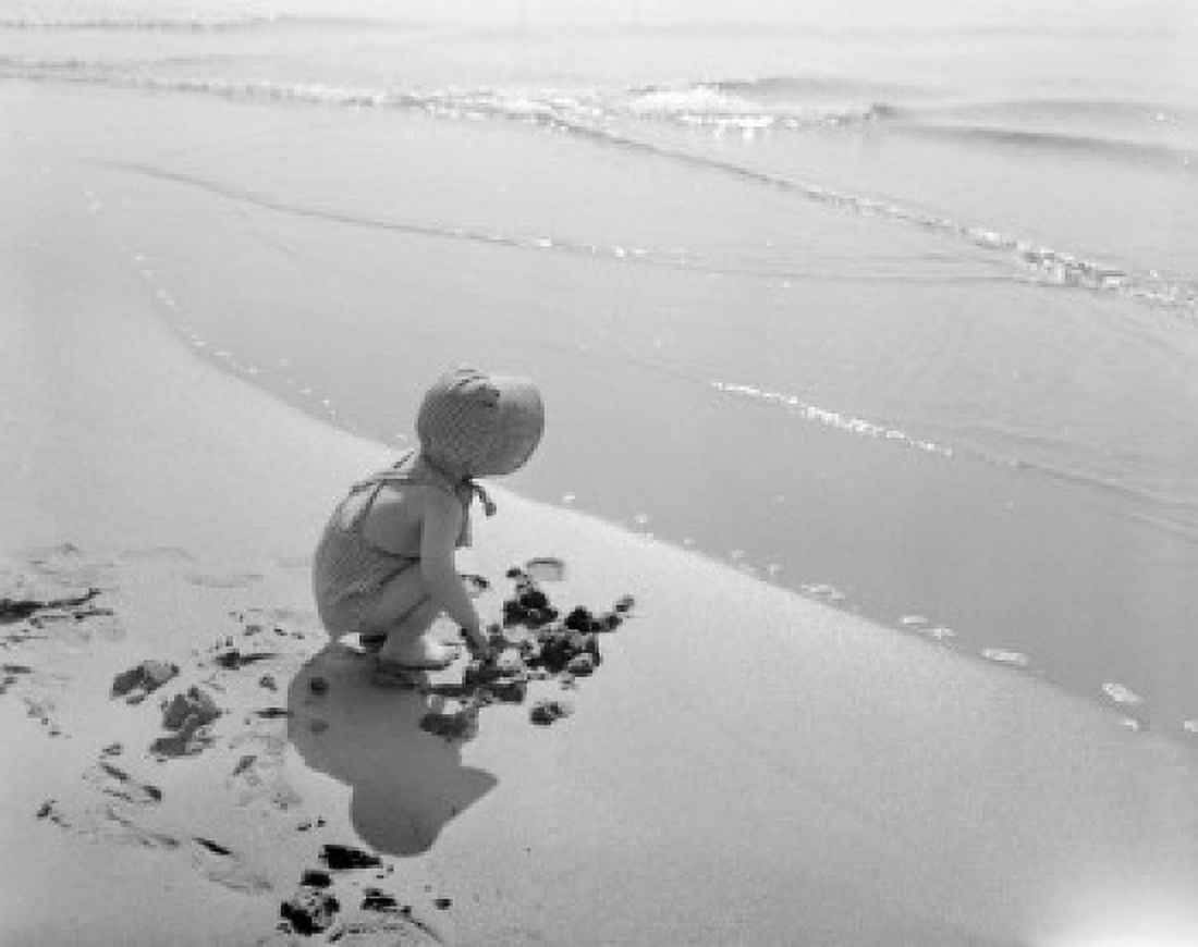 Little girl digging in sand on beach Canvas Art - (18 x 24)