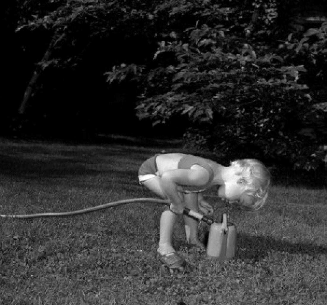 Little girl in garden pouring water into watering can Canvas Art - (18 x 24)