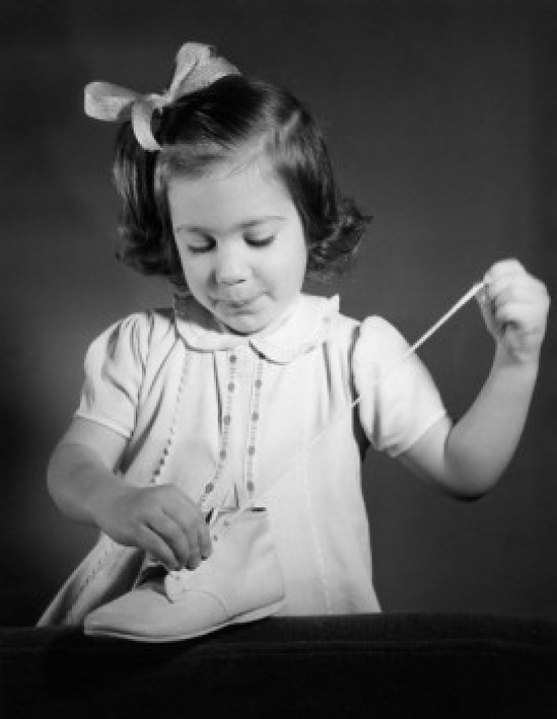 Little girl occupying herself by lacing and unlacing shores Canvas Art - (24 x 36)