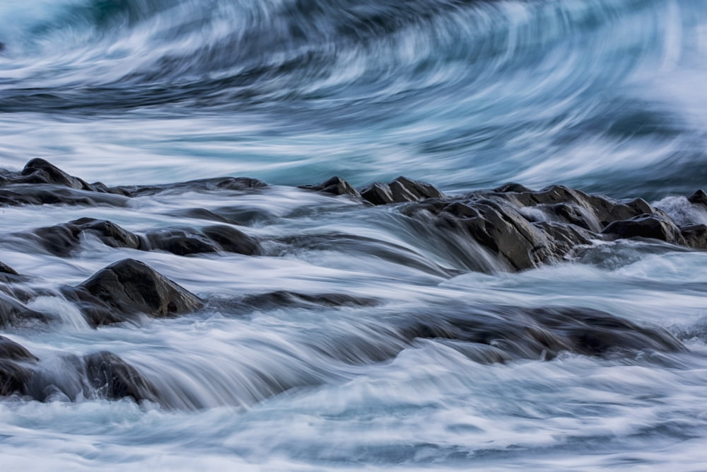 Long exposure of waves striking the coastline and flowing over rocks Iceland Canvas Art - Robert Postma Design Pics (19 x 12)