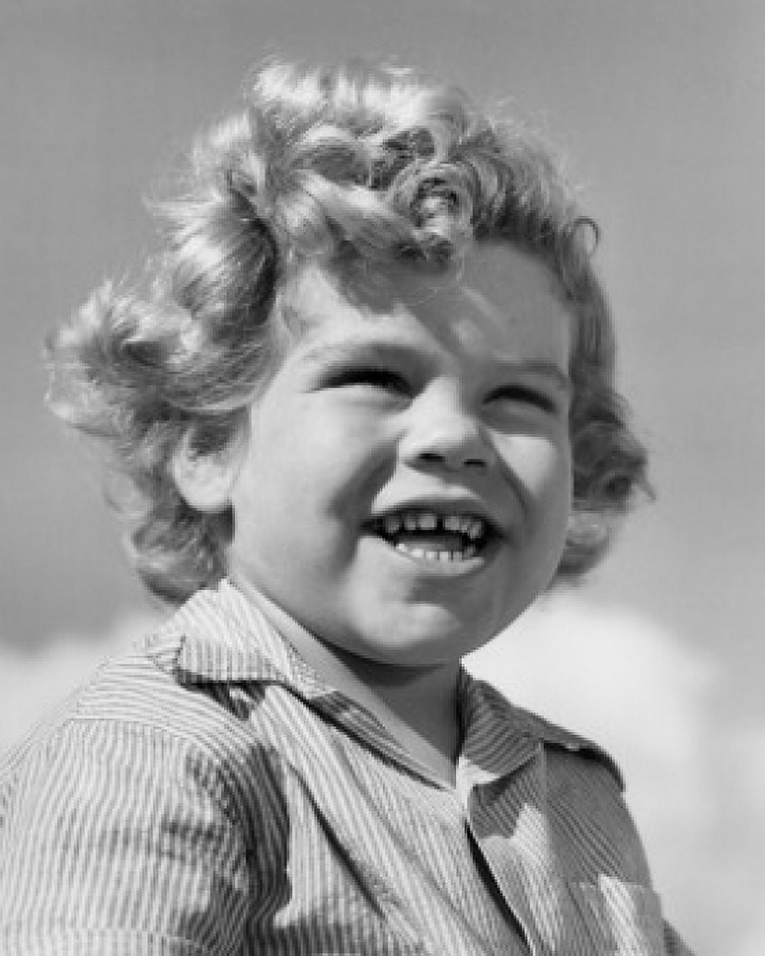 Low-angle portrait of boy smiling in bright sunlight Canvas Art - (24 x 36)