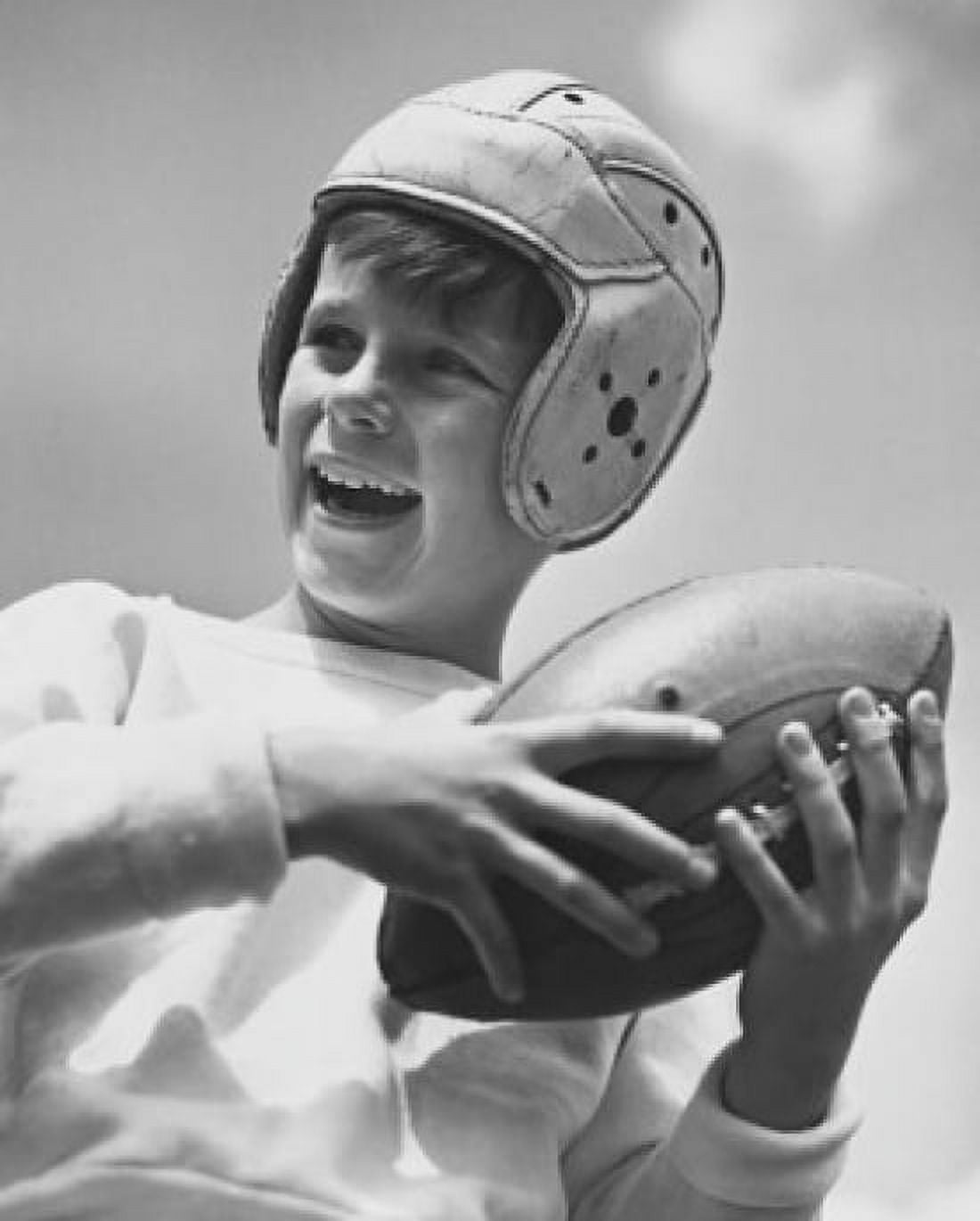 Low angle view of a boy holding a football and smiling Canvas Art - (18 x 24)