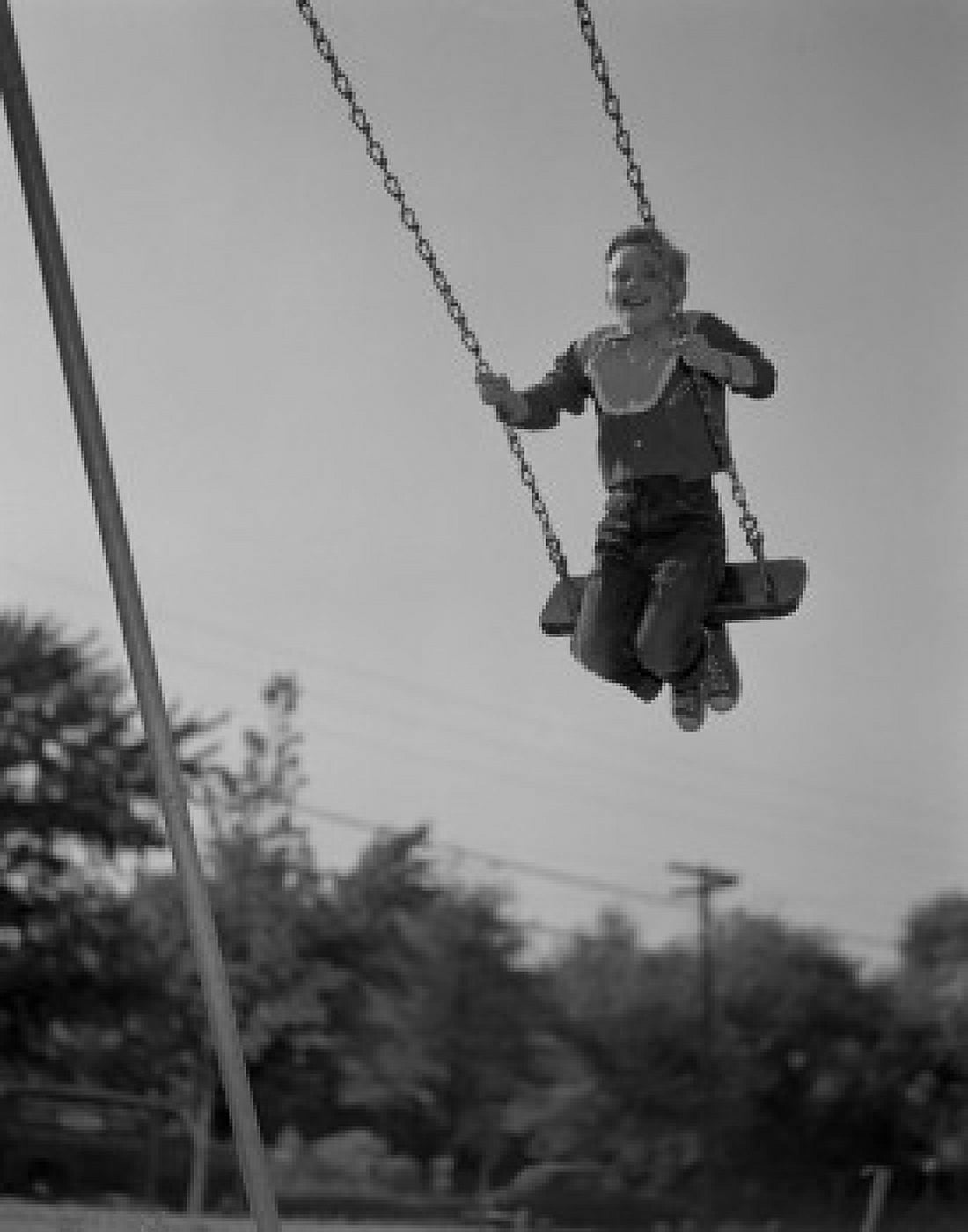 Low angle view of a boy on a swing Canvas Art - (24 x 36)