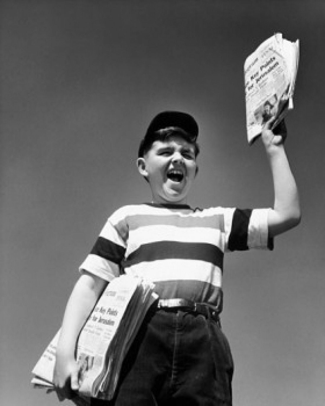 Low angle view of a boy selling newspapers Canvas Art - (24 x 36)