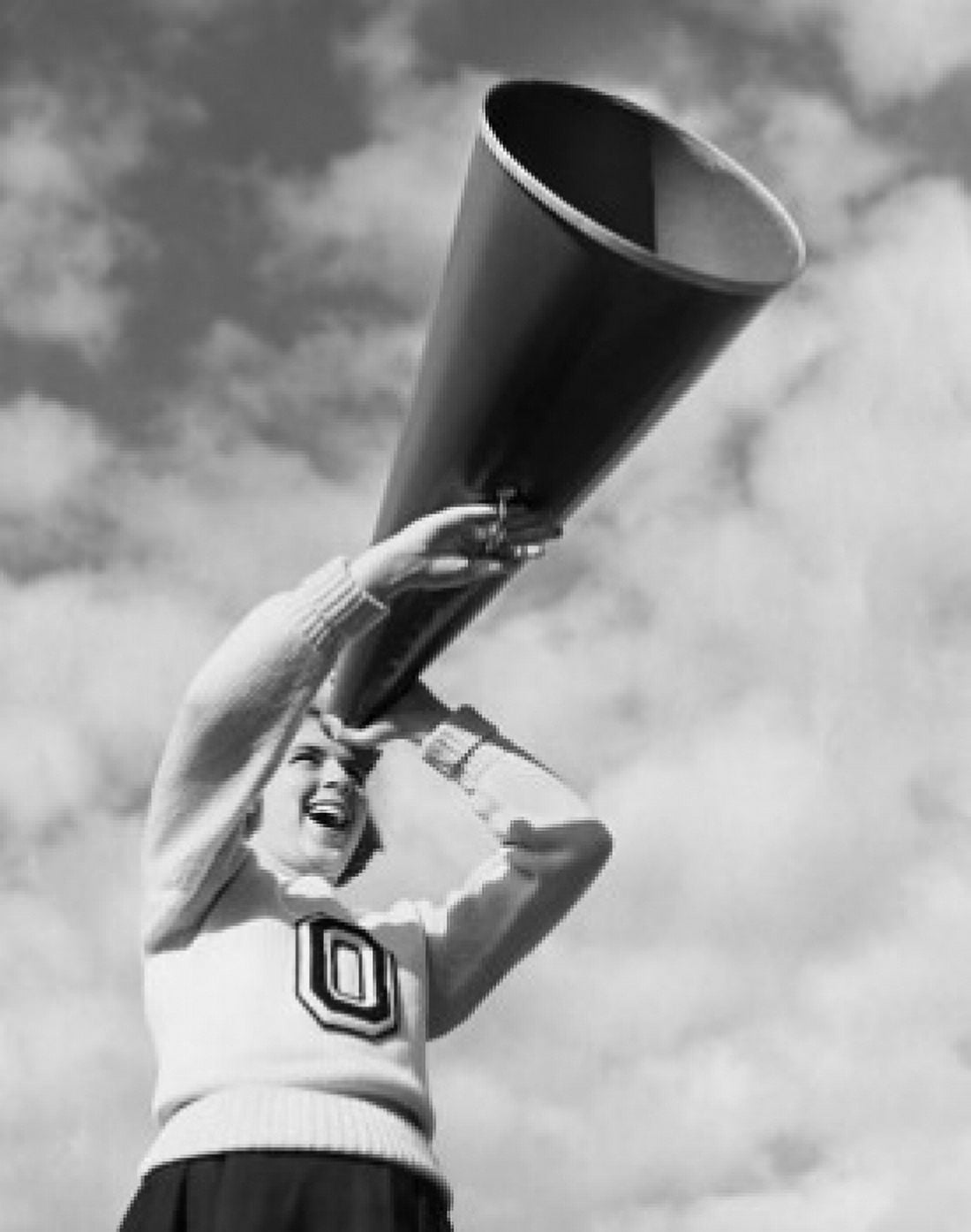 Low angle view of a female cheerleader holding a megaphone and laughing Canvas Art - (24 x 36)