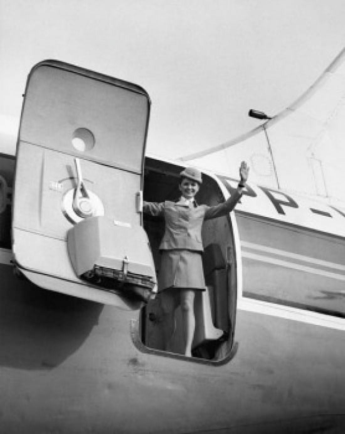 Low angle view of a female flight attendant standing at the open door of an airplane and waving Canvas Art - (24 x 36)