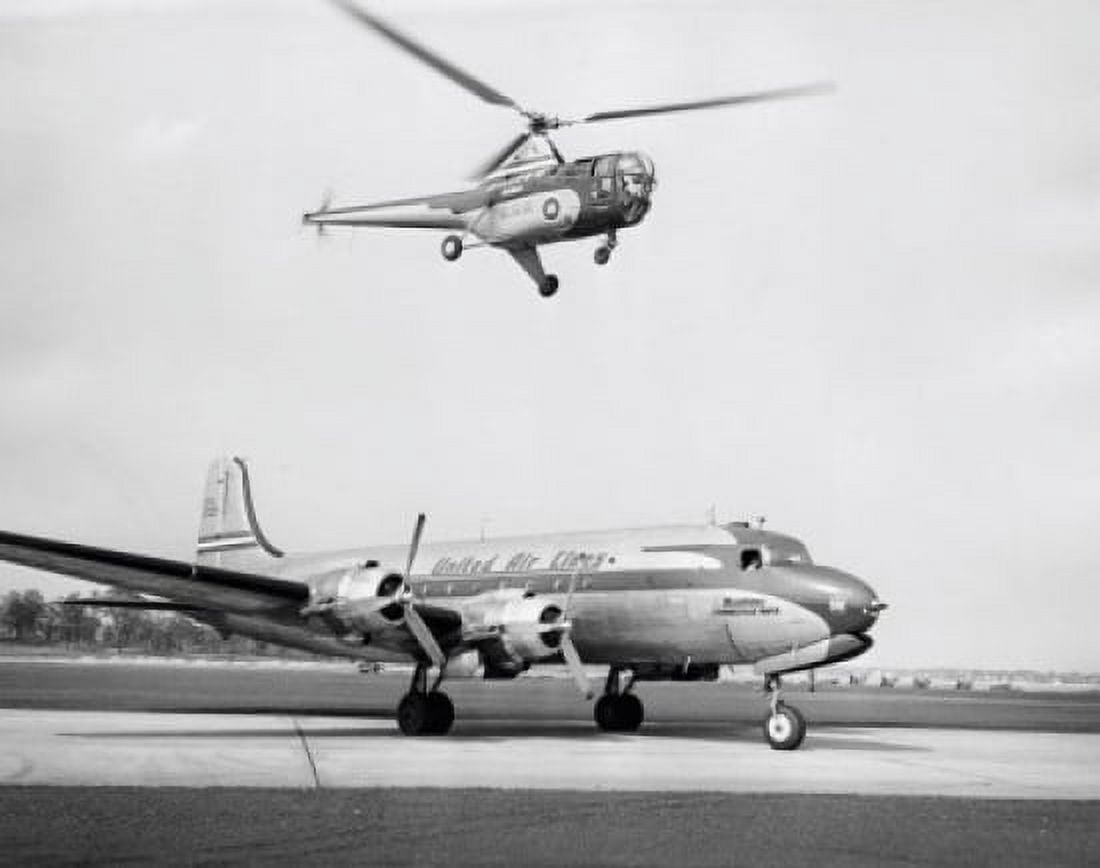 Low angle view of a helicopter in flight and an airplane at an airport Sikorsky Helicopter Douglas DC-4 Canvas Art - (18 x 24)