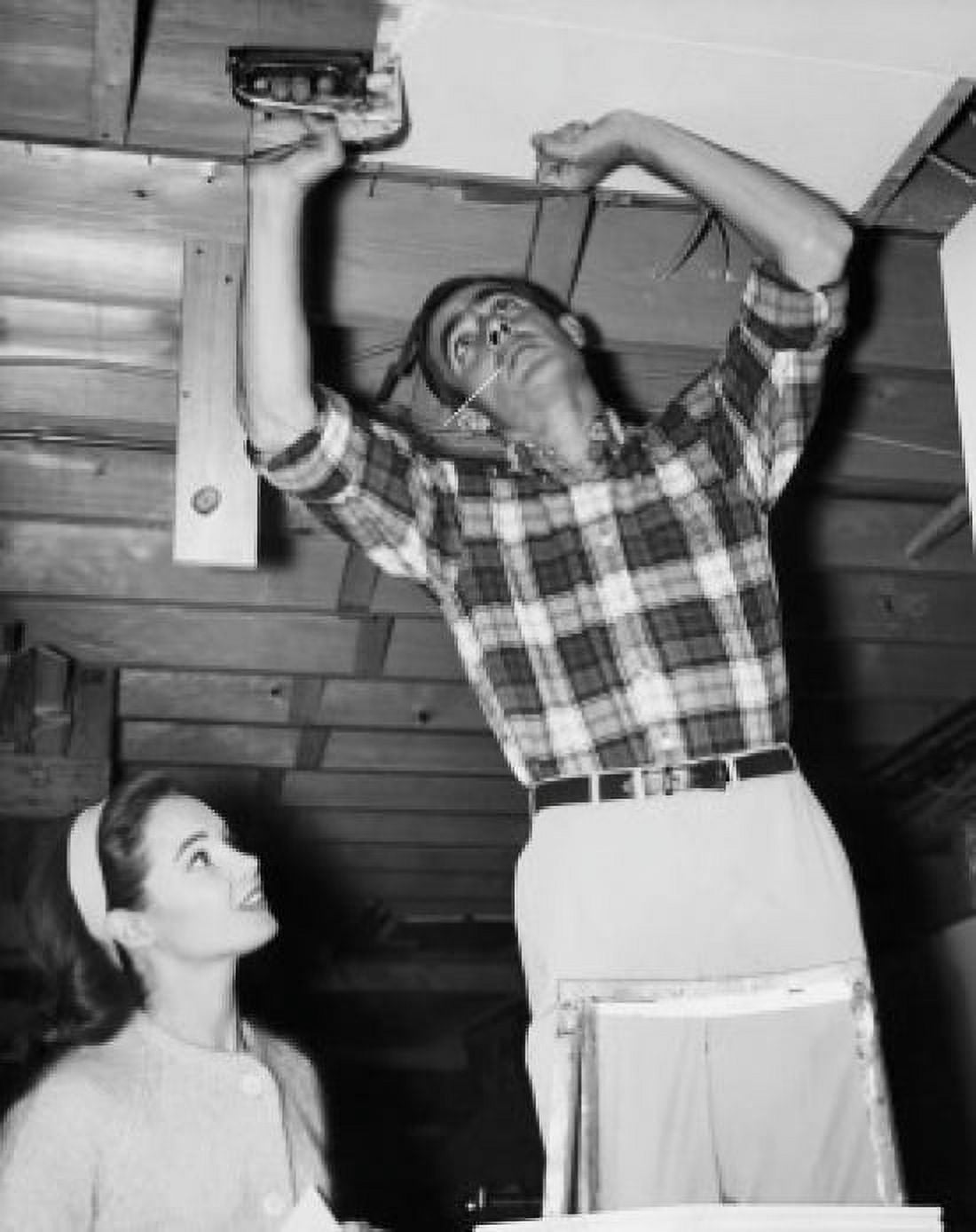 Low angle view of a mid adult man applying panelling to the ceiling with a mid adult woman looking at him Canvas Art - (18 x 24)