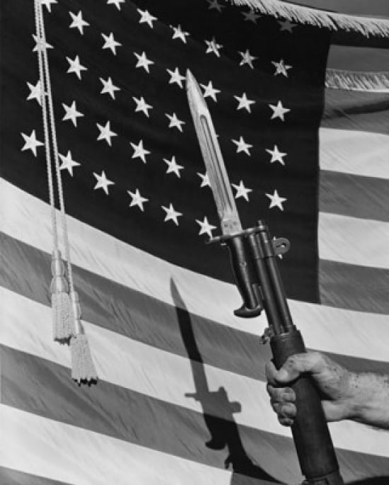 Low angle view of a persons hand holding a rifle with bayonet in front of an American Flag Canvas Art - (18 x 24)
