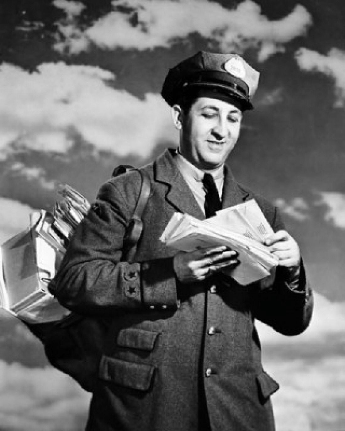 Low angle view of a postman holding mail Canvas Art - (24 x 36)