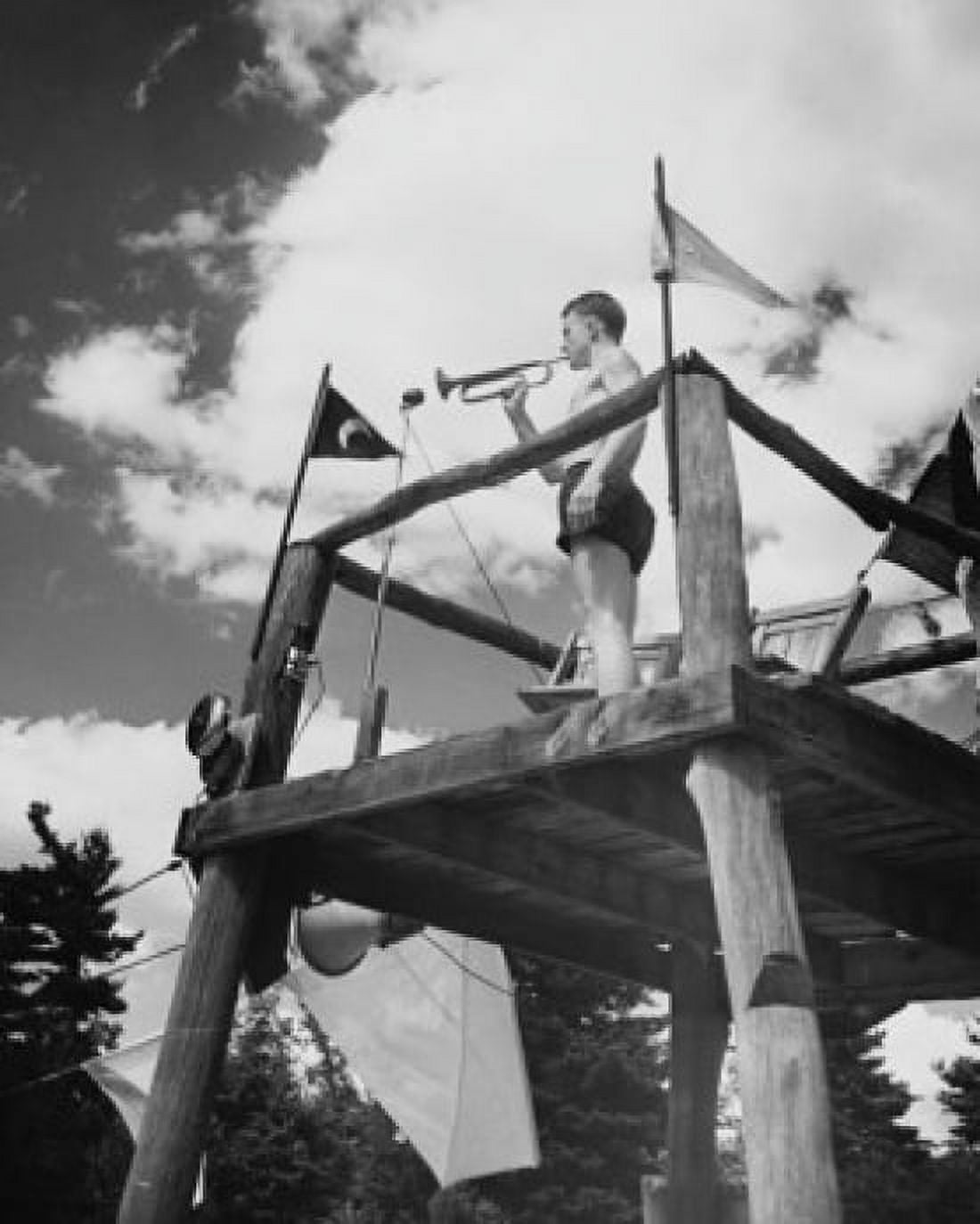 Low angle view of a teenage boy blowing a bugle at a scout camp Canvas Art - (18 x 24)