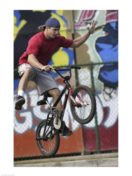 Low angle view of a teenage boy performing a stunt on a bicycle Canvas Art - (18 x 24)