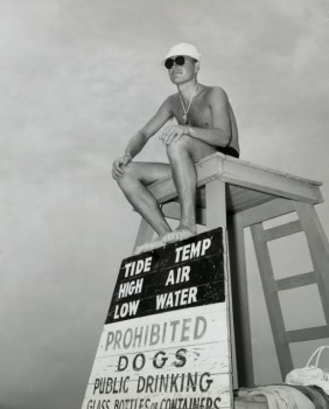 Low angle view of a young man sitting on a lifeguards chair Canvas Art - (18 x 24)