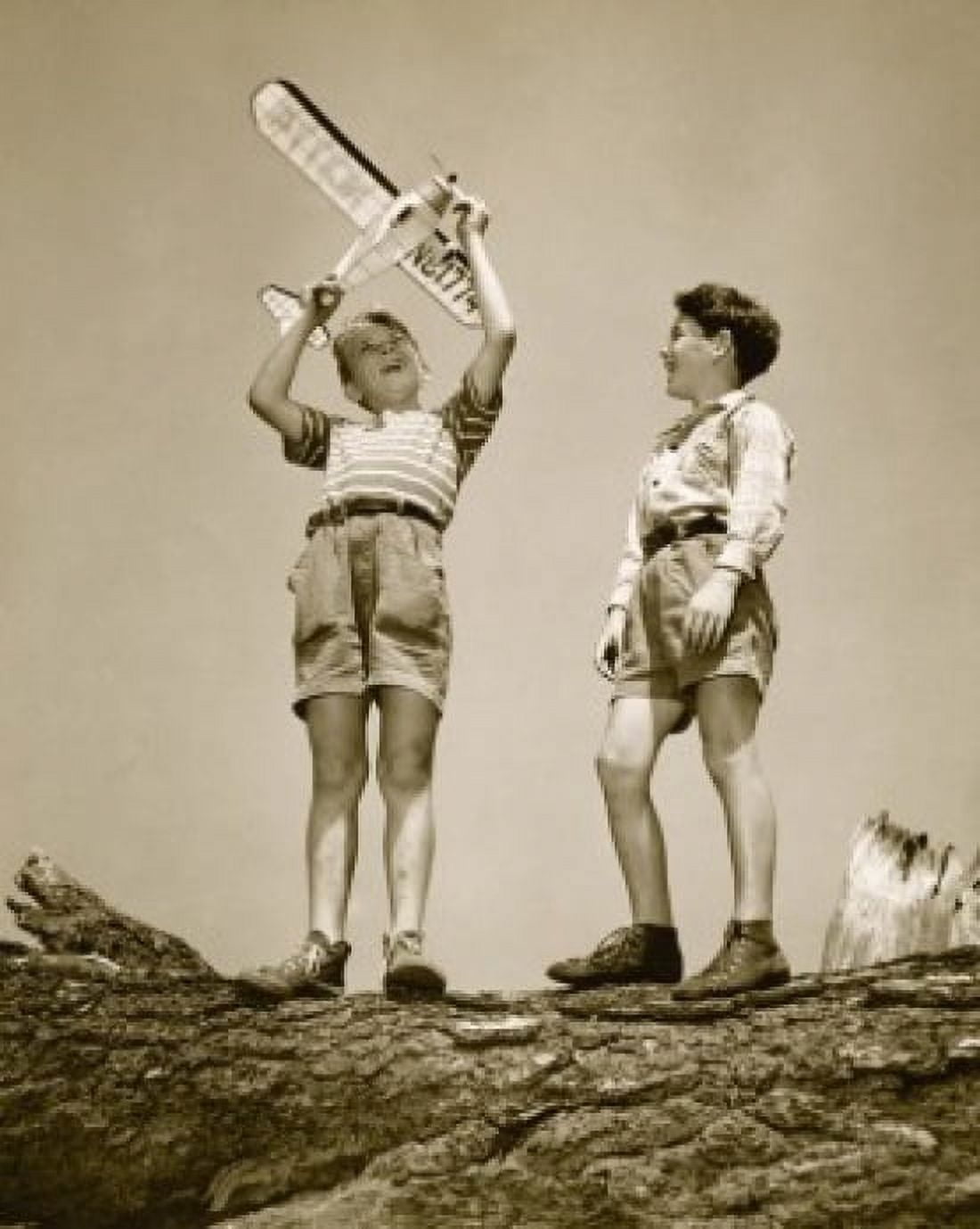 Low angle view of two boys playing with a model airplane Canvas Art - (18 x 24)