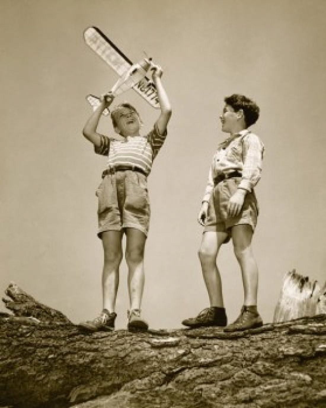 Low angle view of two boys playing with a model airplane Canvas Art - (24 x 36)