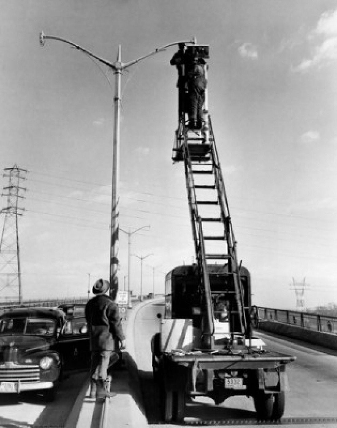Low angle view of two men repairing street light Canvas Art - (24 x 36)