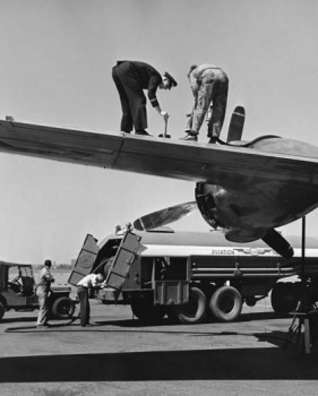 Low angle view of two people working on a wing of an airplane New York International Airport New York City New York USA Canvas Art - (24 x 36)