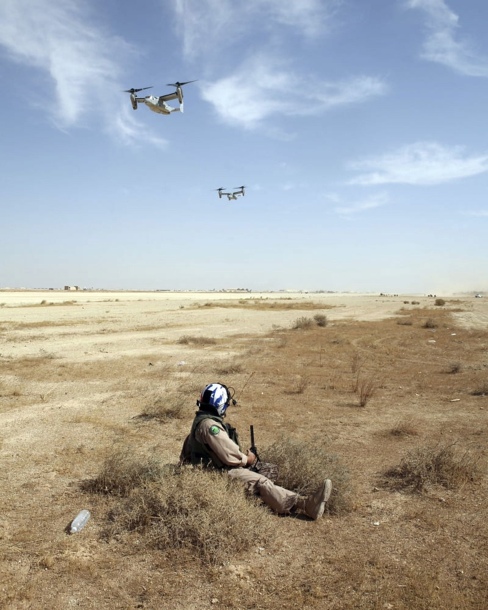MV-22B Ospreys fly over US Navy Hospital Corpsman as he acts as an injured pilot waiting to be rescued Canvas Art - Stocktrek Images (25 x 32)