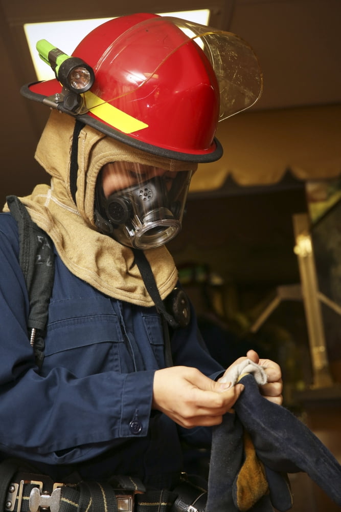 Machinery repairman puts on fire fighting gloves Canvas Art - Stocktrek Images (23 x 35)