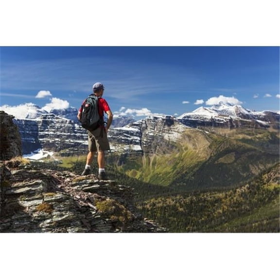 Male Hiker Standing On Top of Mountain Ridge Overlooking Snow Peaked Mountains & Forest Valley Below with Blue Sky & Poster Print by Michael Interisano - 38 x 24 - Large