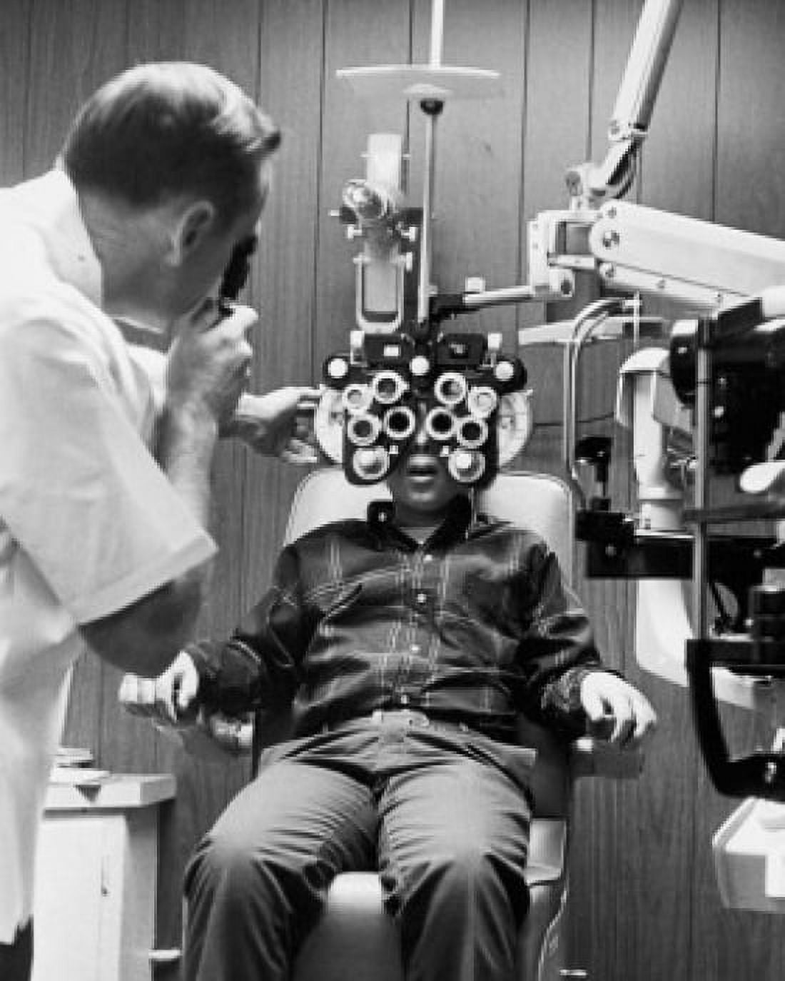 Male optometrist examining the eyes of a patient Canvas Art - (18 x 24)