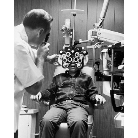 Male optometrist examining the eyes of a patient Canvas Art - (24 x 36)