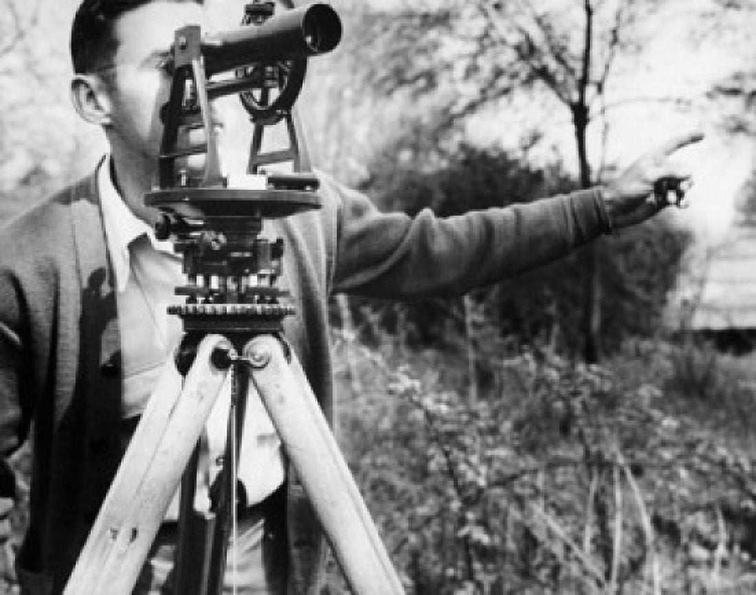 Male surveyor looking through a theodolite Canvas Art - (24 x 36)