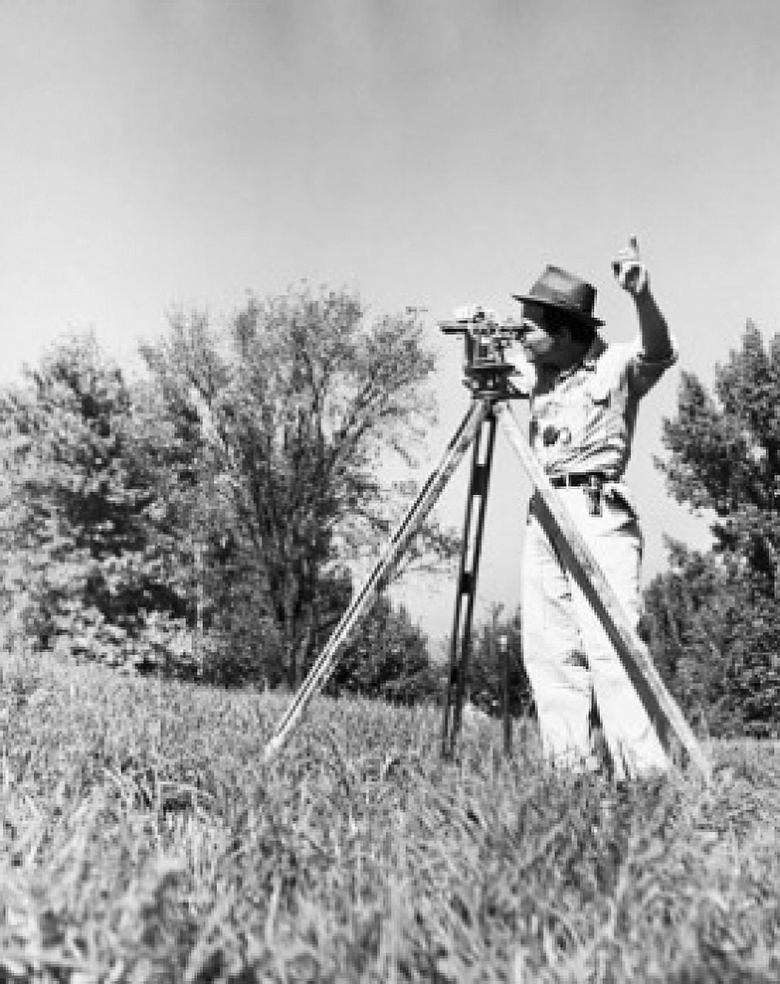 Male surveyor standing in a field and looking through a theodolite Canvas Art - (24 x 36)