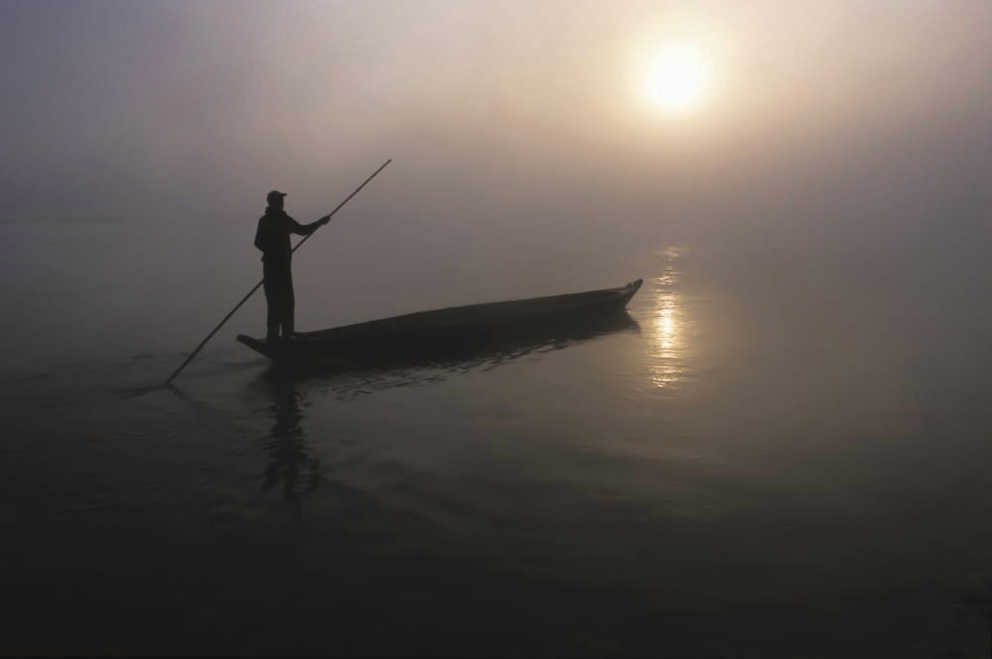 A Man Pushes His Dugout Canoe Along The Rapti River Near Sauraha And Chitwan National Park At Dawn Nepal Canvas Art - Sean White Design Pics (38 x 24)