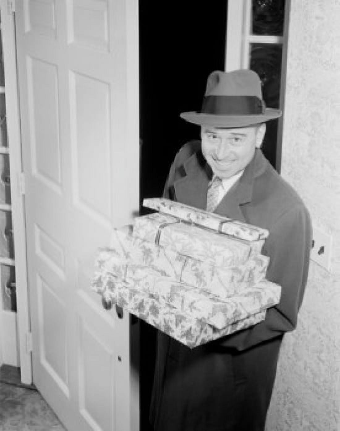 Man carrying Christmas presents in doorway Canvas Art - (18 x 24)