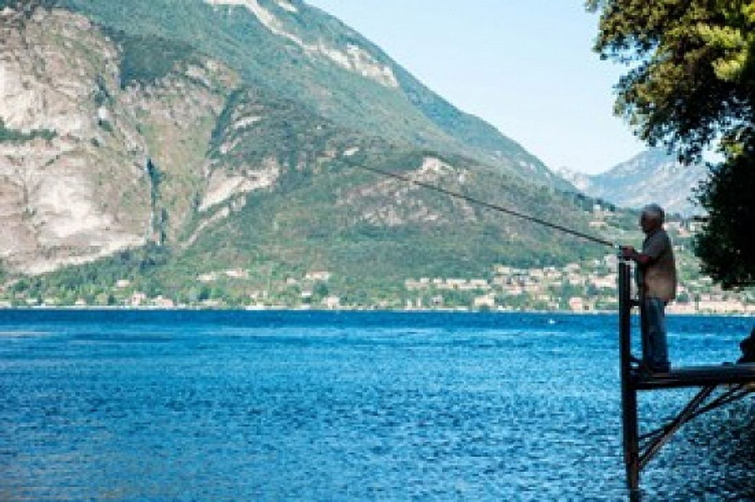Man fishing from dock on edge of Lake Como Varenna Lombardy Italy Canvas Art - Panoramic Images (36 x 24)