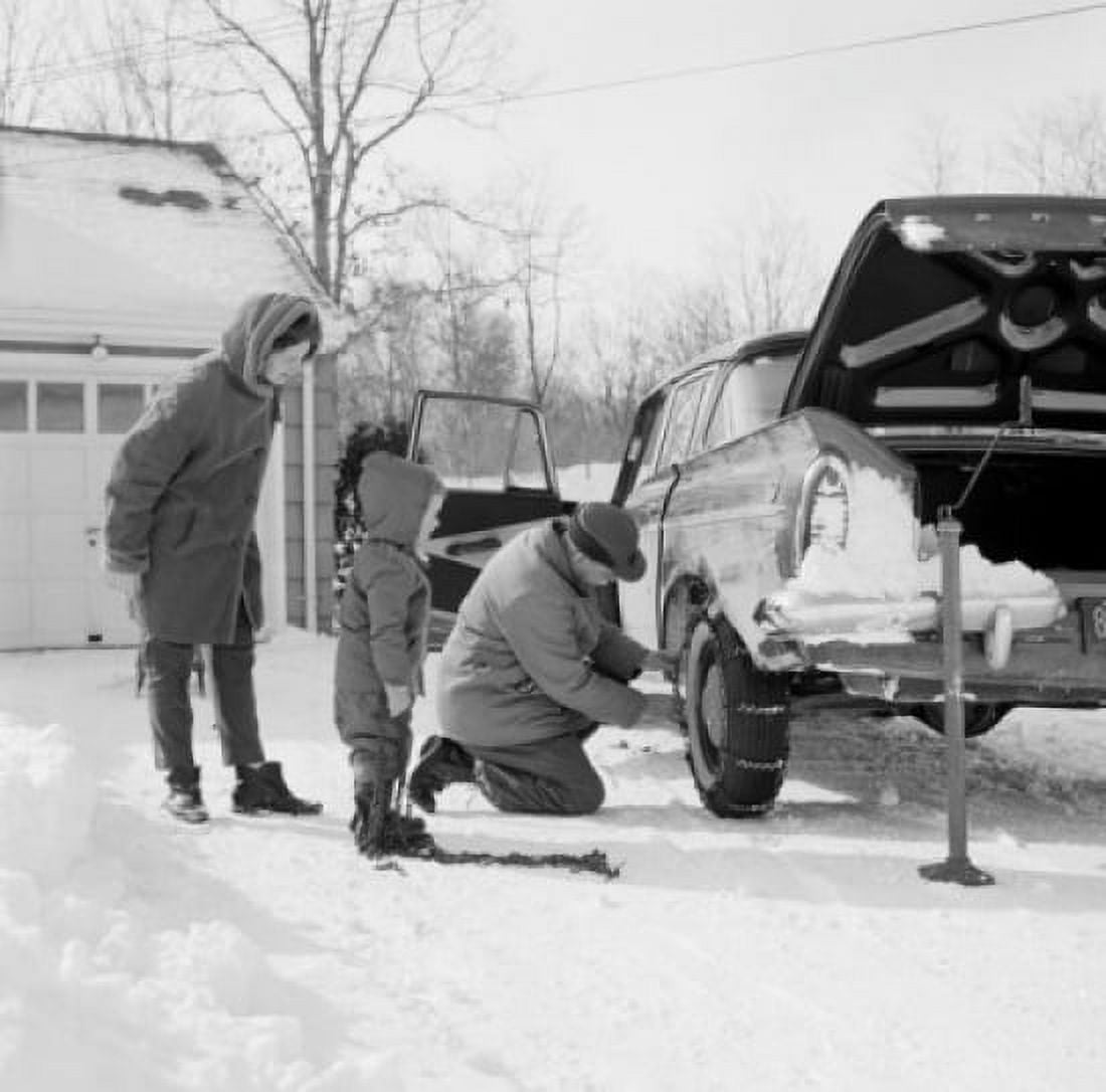Man installing snow chain on cars wheel wife and son watching Canvas Art - (24 x 36)