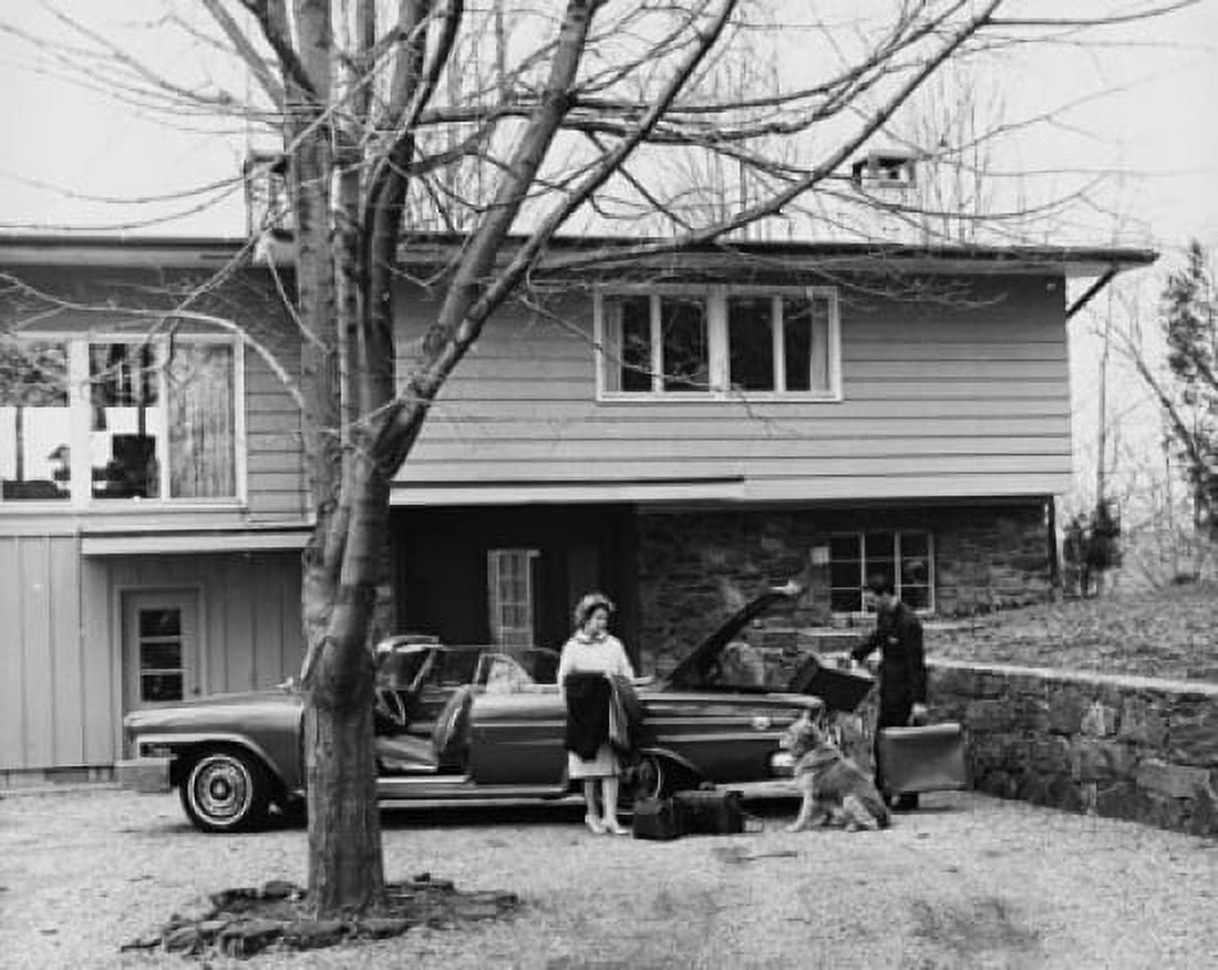 Man loading luggage into the trunk of a car and a woman leaning against it Canvas Art -  (18 x 24)