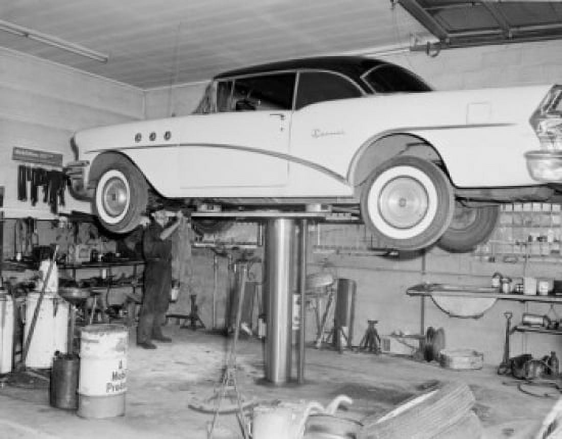 Man repairing car lifted up in garage Canvas Art - (24 x 36)