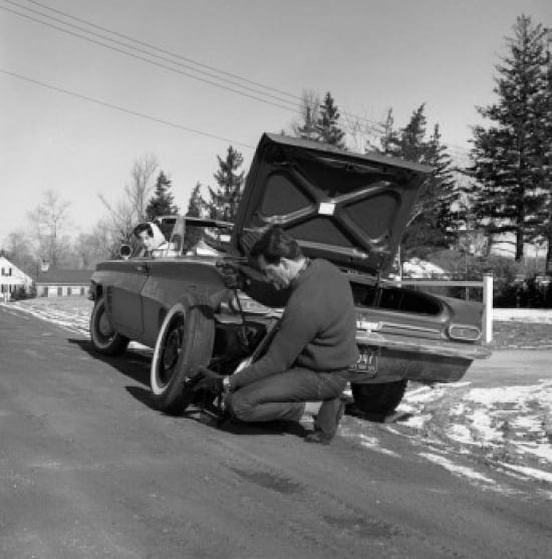 Man repairing car wheel on road Canvas Art - (18 x 24)