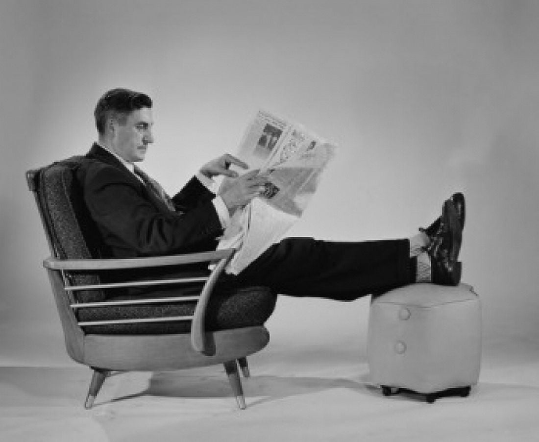 Man sitting in armchair with ottoman reading newspaper Canvas Art - (18 x 24)