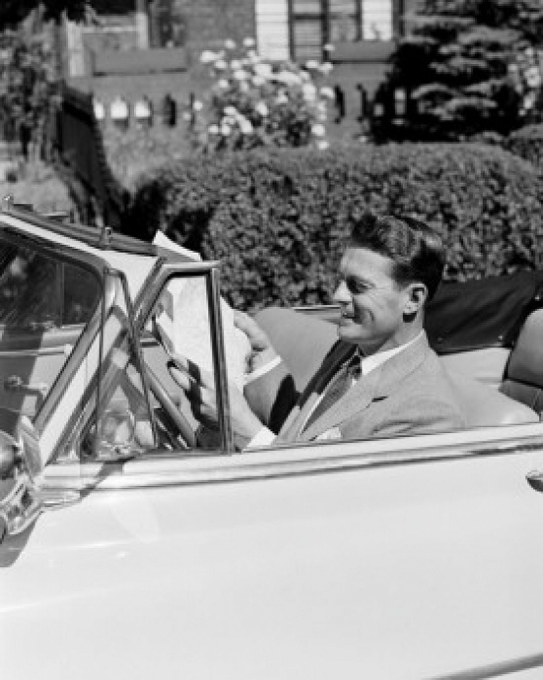 Man sitting in convertible car and reading newspaper Canvas Art - (24 x 36)