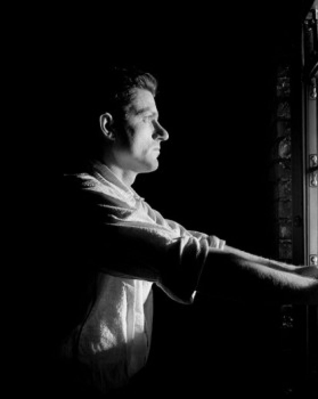Man standing and looking through window side view Canvas Art - (18 x 24)