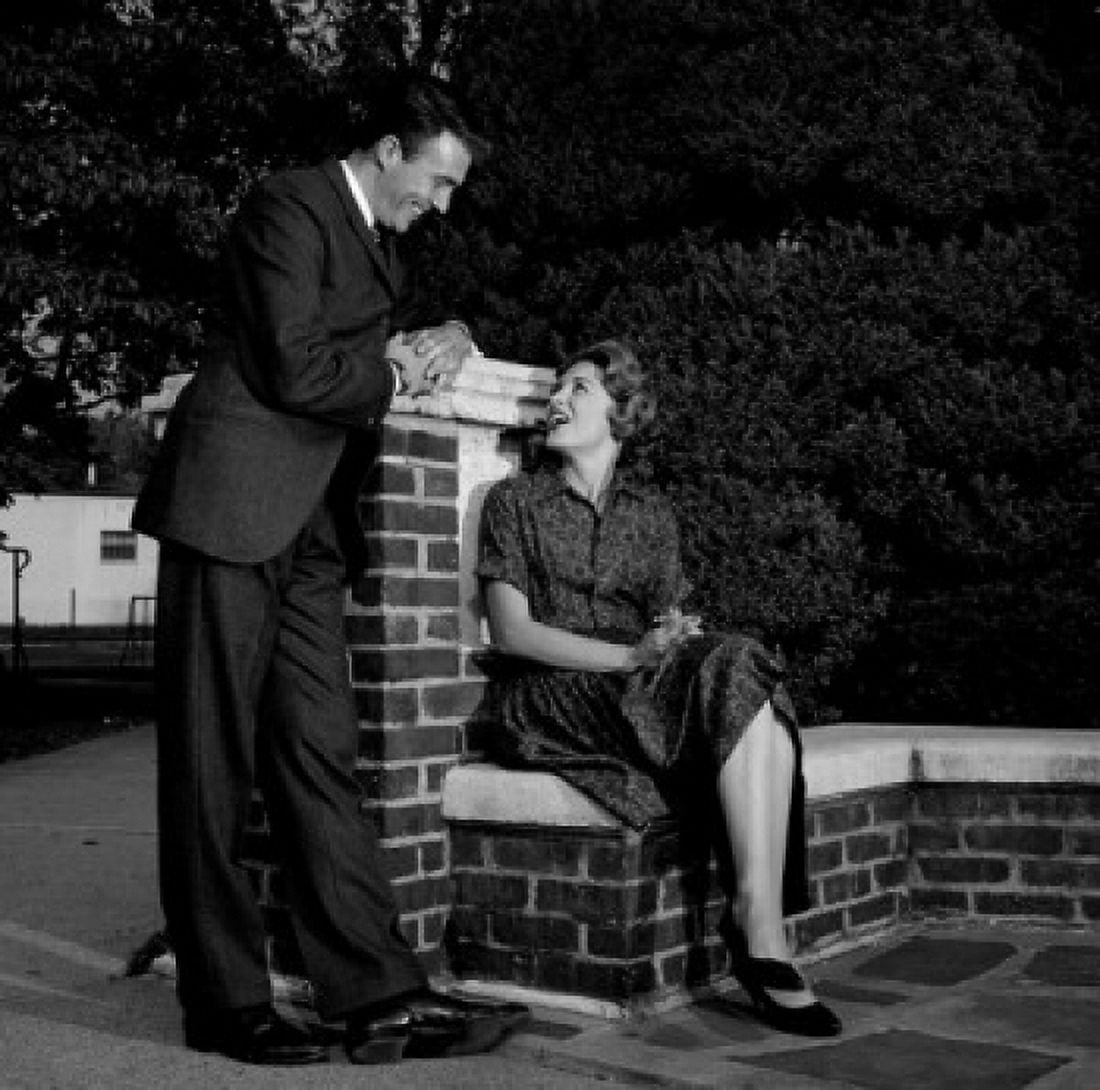 Man talking to woman sitting on wall Canvas Art - (24 x 36)