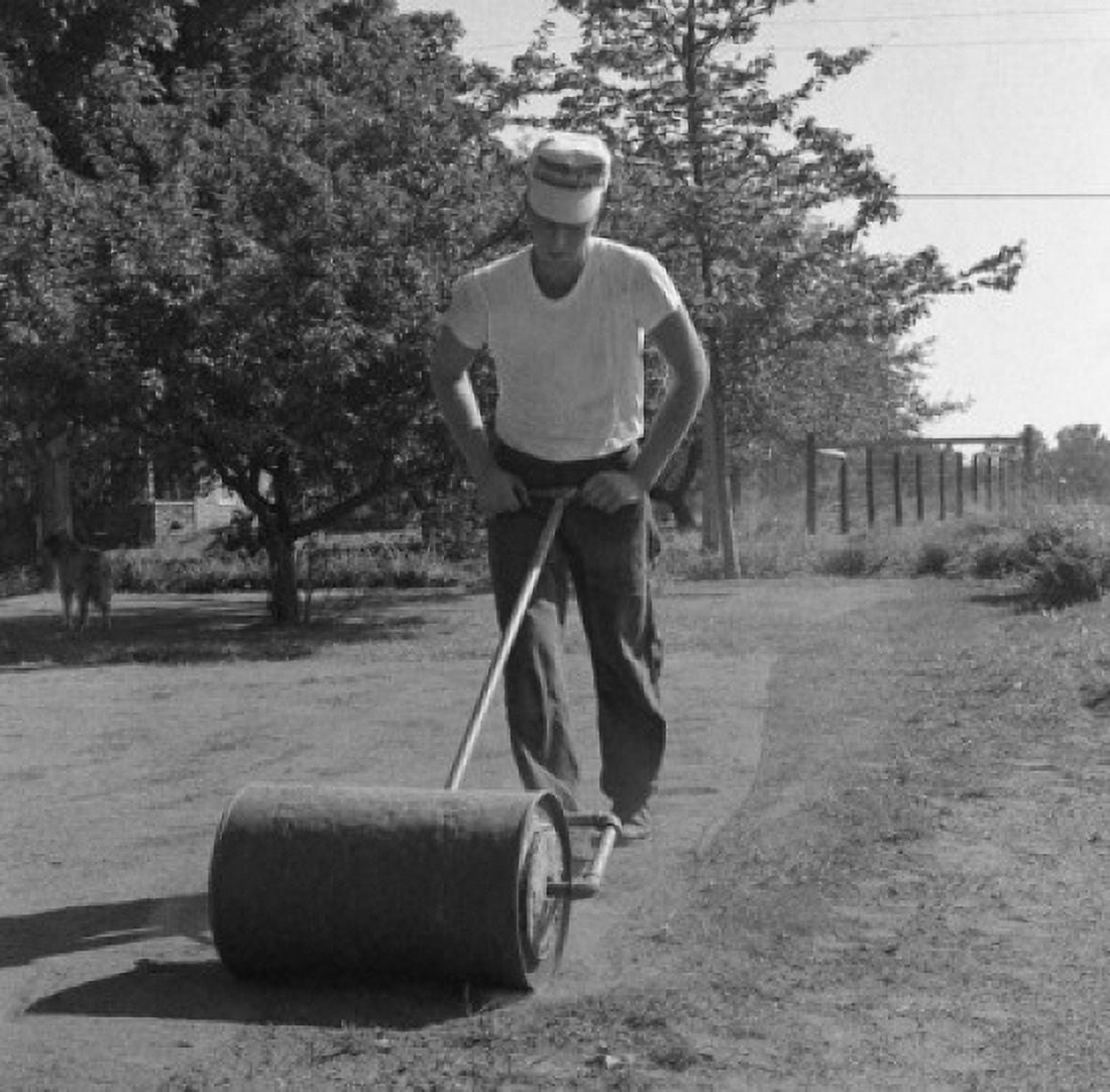 Man with lawn roller Canvas Art - (24 x 36)