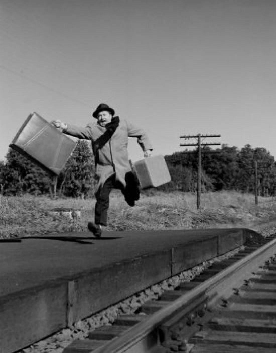 Man with suitcases running along railroad track Canvas Art - (24 x 36)