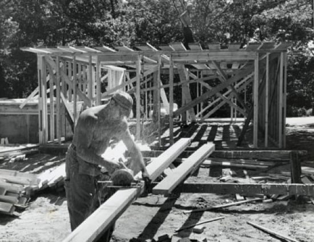 Manual worker sawing a wooden plank on a construction site Canvas Art - (18 x 24)