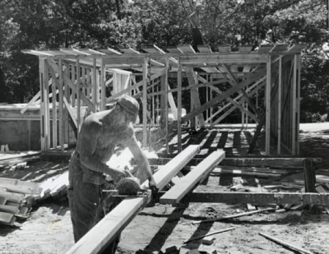 Manual worker sawing a wooden plank on a construction site Canvas Art - (24 x 36)