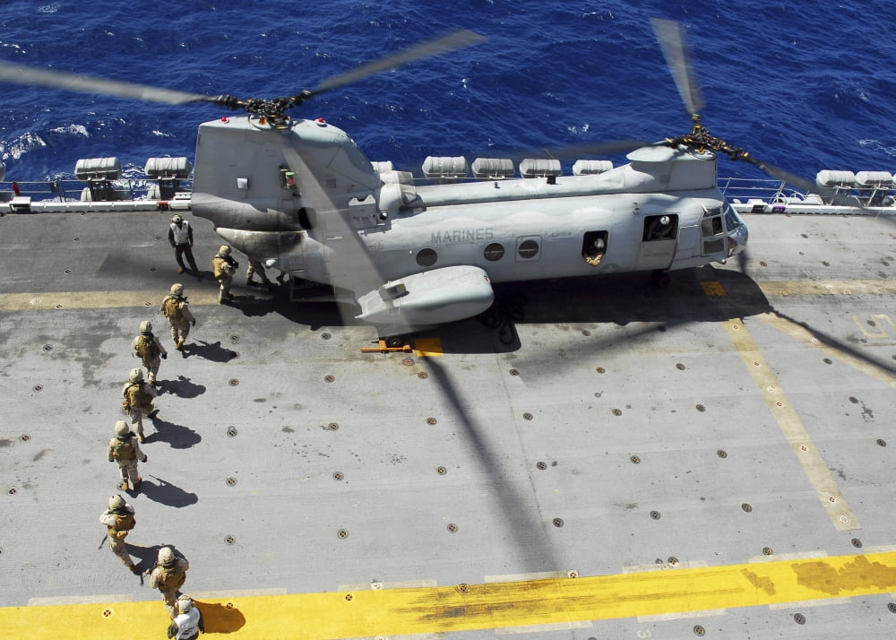 Marines board a CH-46E Sea Knight helicopter on the flight deck of USS Peleliu Canvas Art - Stocktrek Images (33 x 24)