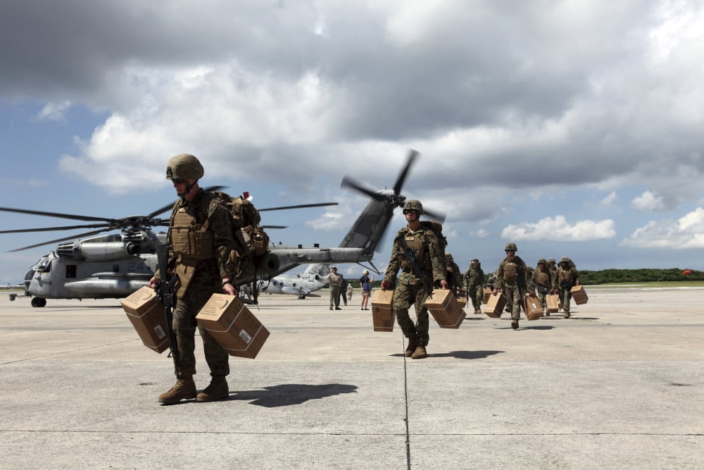 Marines carry supplies to a hangar Canvas Art - Stocktrek Images (34 x 23)